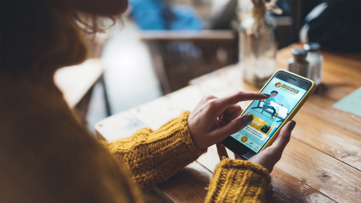 Eine Frau benutzt die My BDAE-App auf ihrem Smartphone